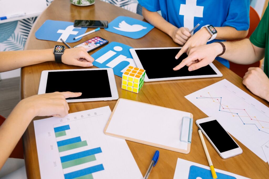 social media team using digital tablet with social media icons desk